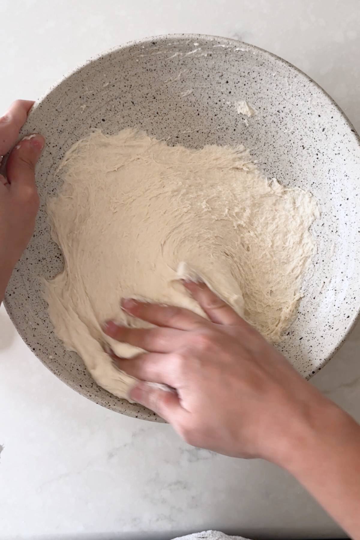 leveraging the walls of the bowl to mix the dough well