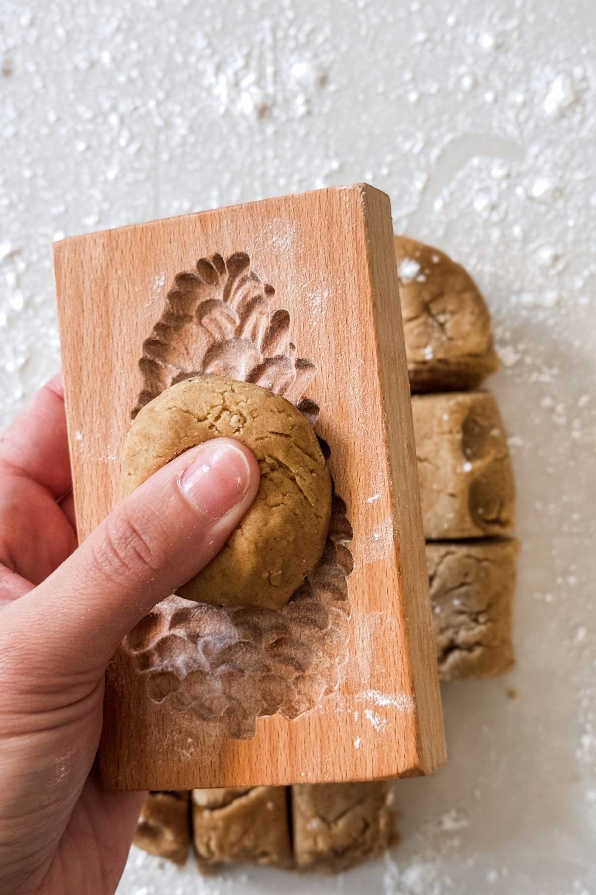 pressing gingerbread cookie dough on the wooden mold