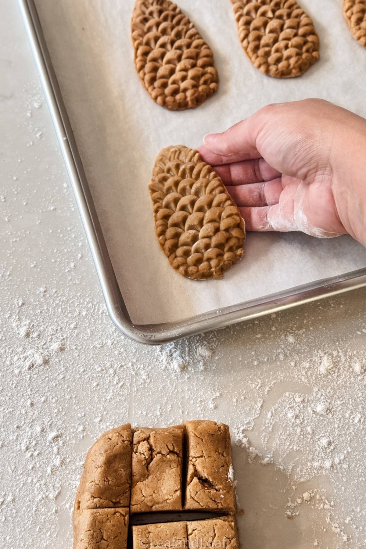 putting gingerbread cookie on a baking sheet