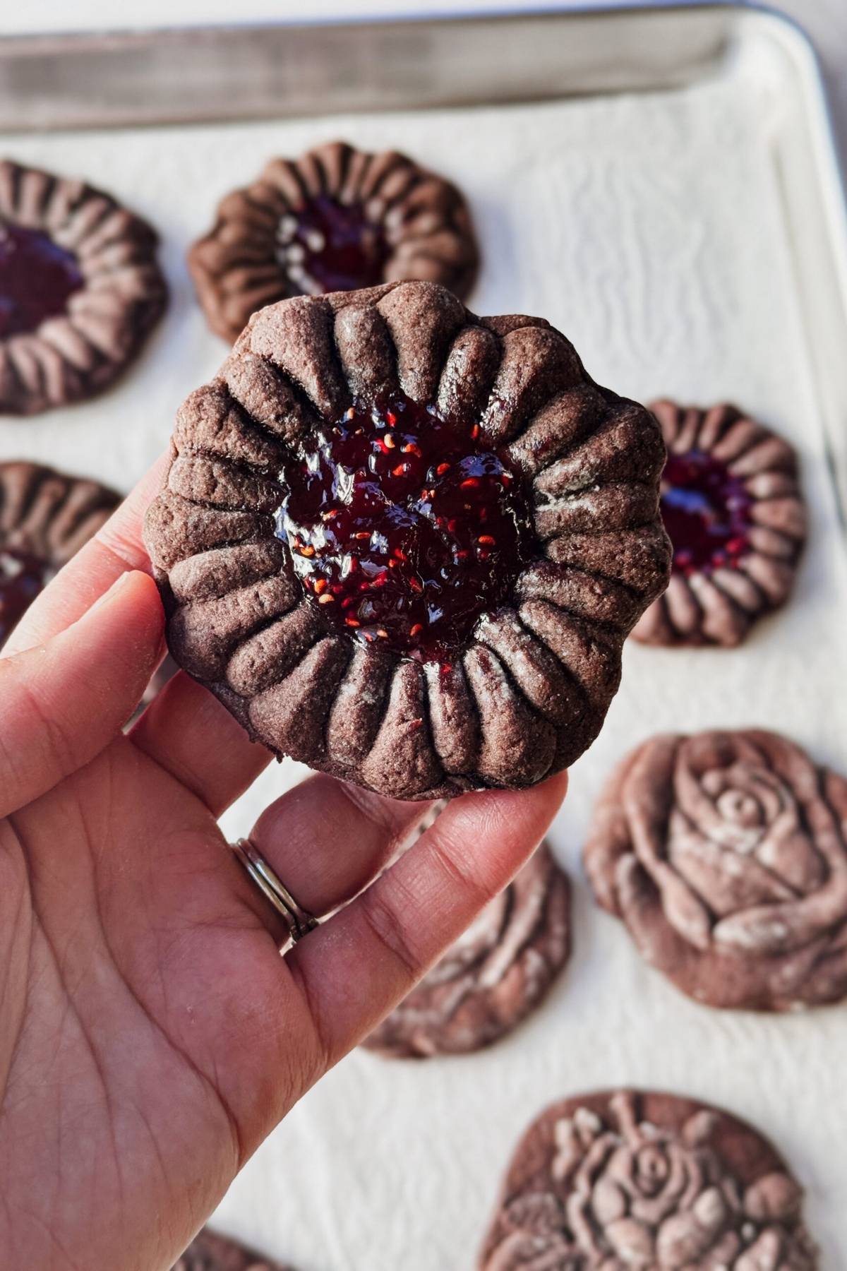 holding a Chocolate Molded Cookie with jam in the middle