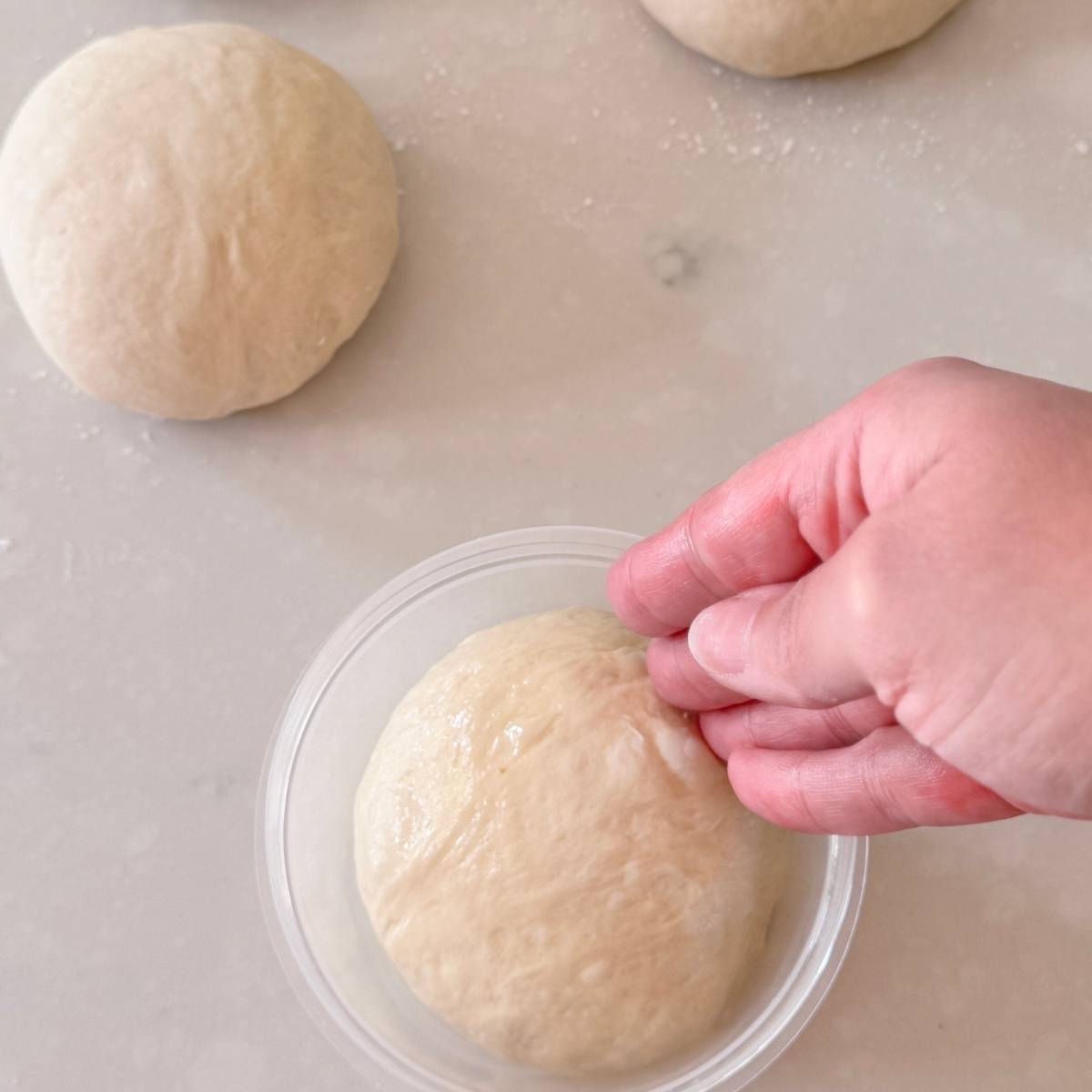 putting pizza dough in oiled container