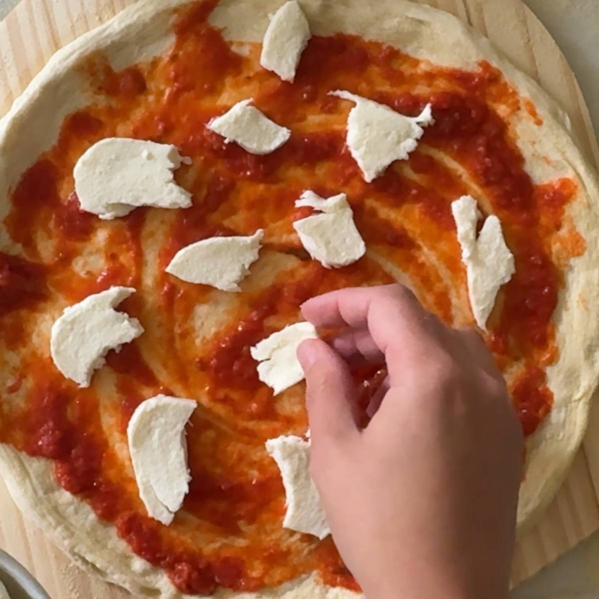 topping pizza dough with cheese