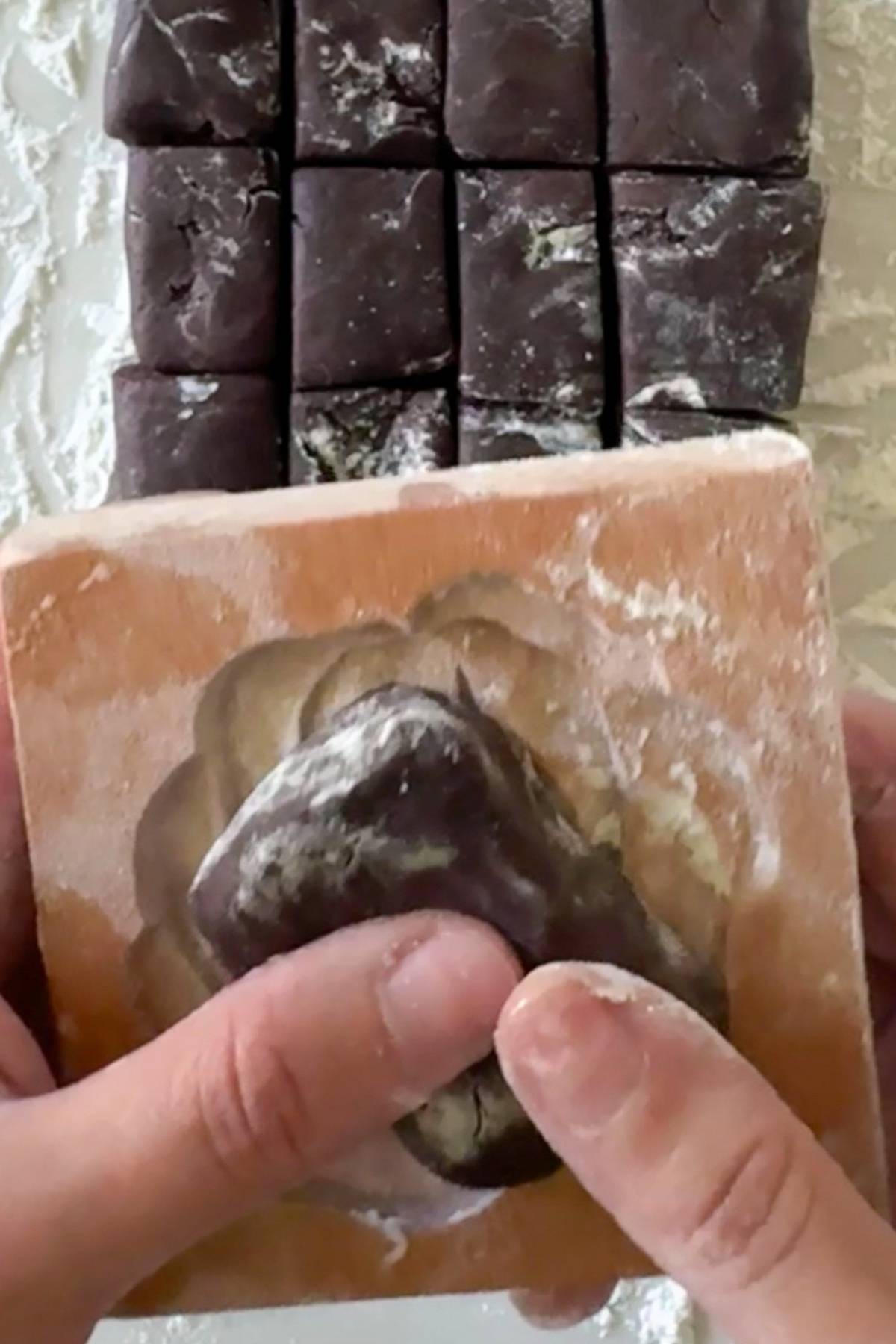 pressing the dough on the wooden mold