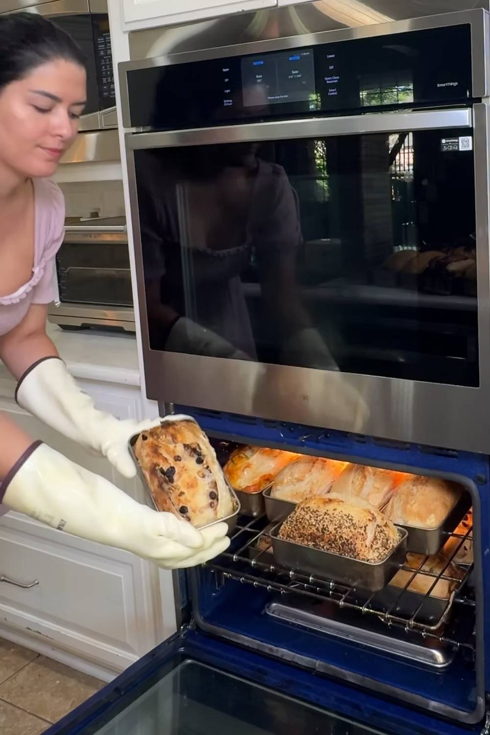 Maria removing bread baked using her two pan method from the oven