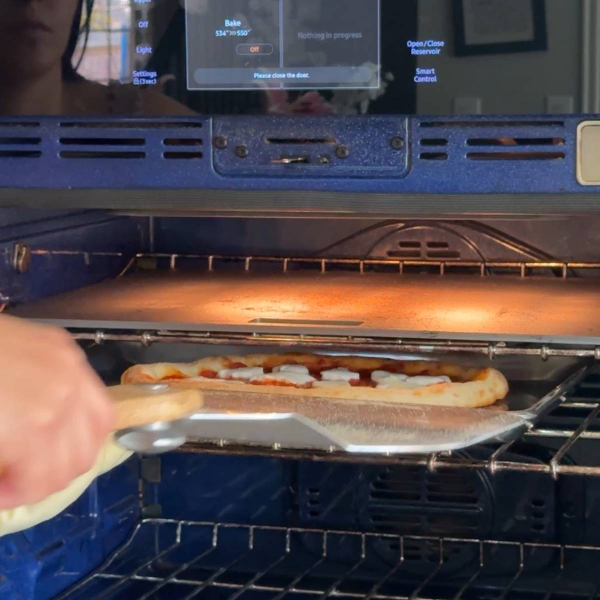 Baking the pizza for two more minutes in the oven