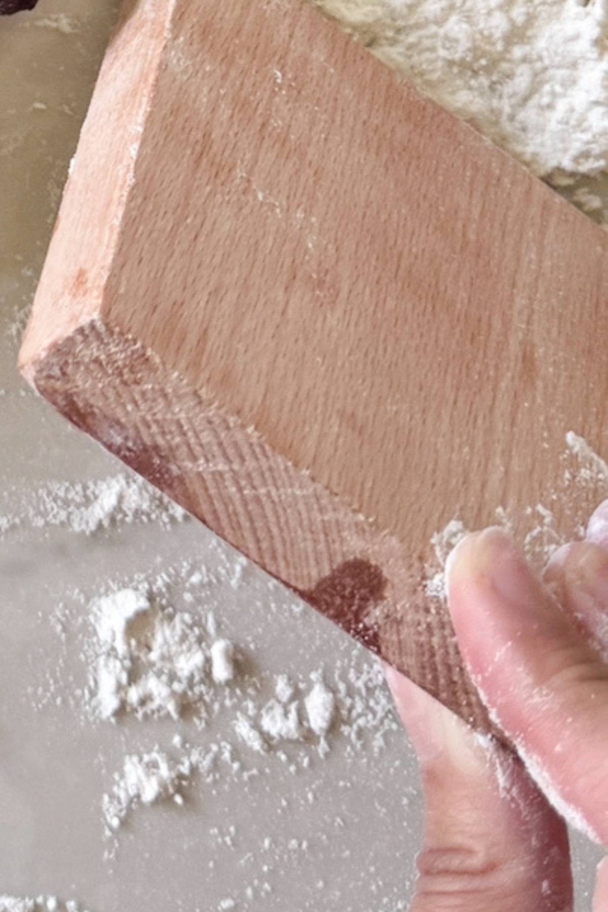 Tapping excess flour from wooden mold