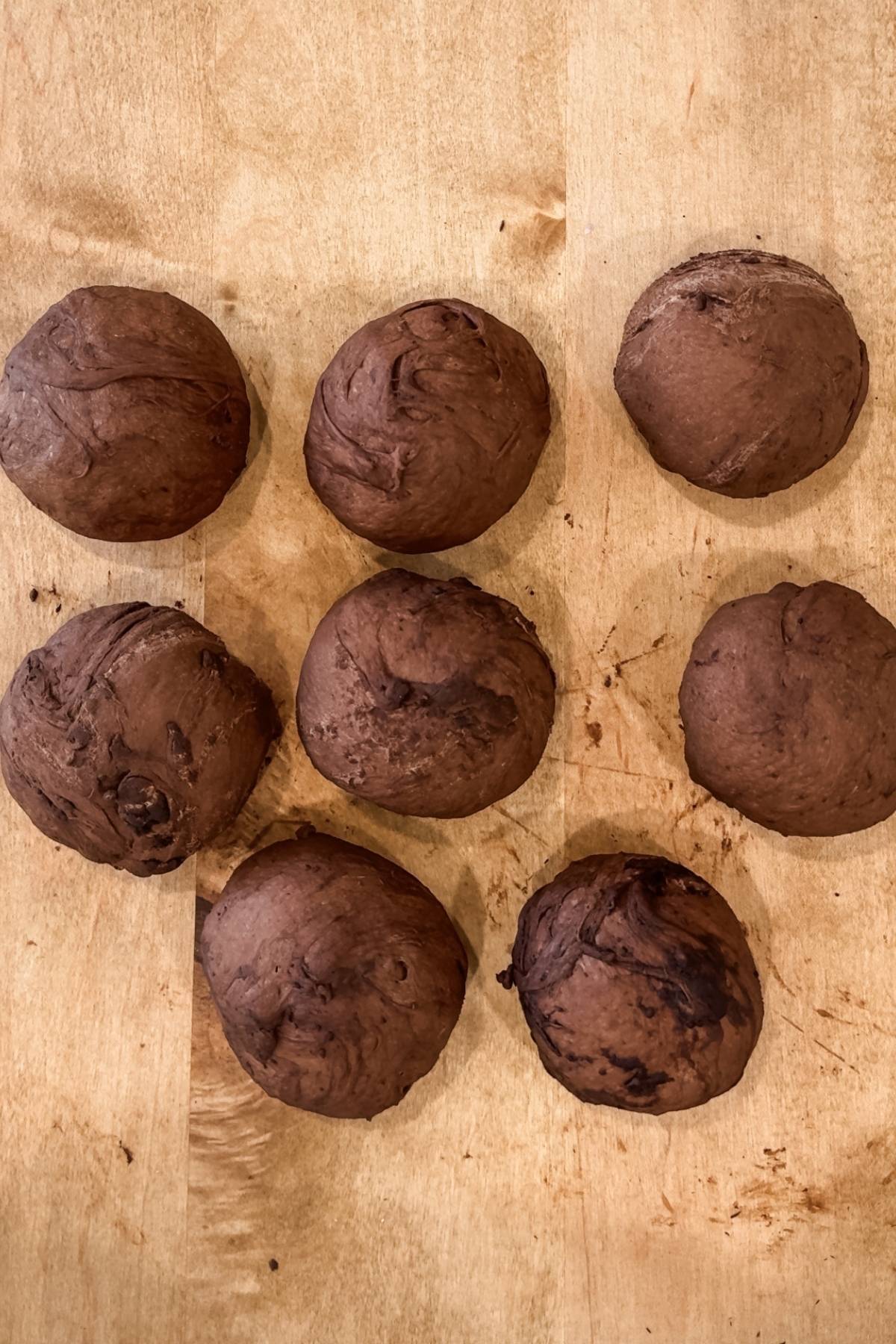 Shaping chocolate bagels dough into balls