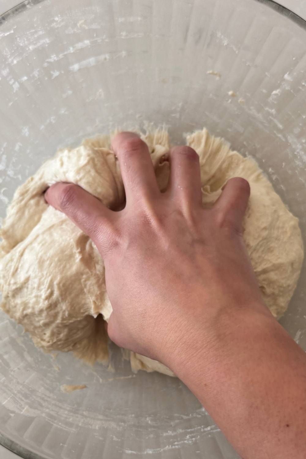 mixing pizza dough by hand until the dough is smooth
