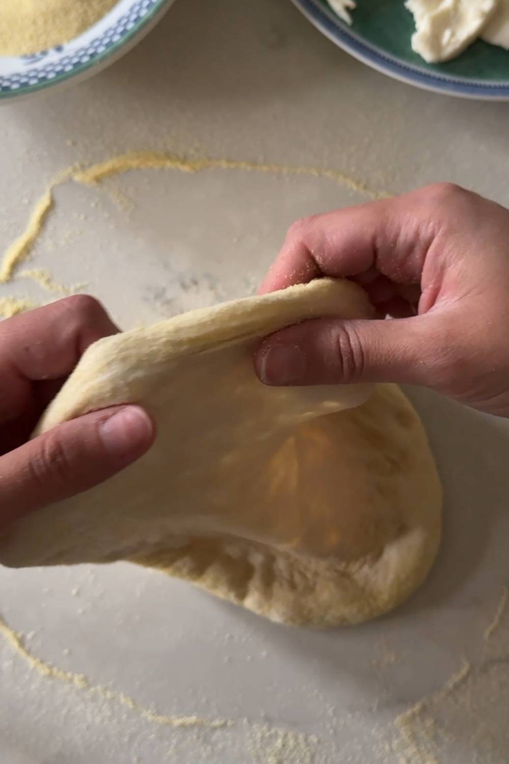 using a wheel motion to shape sourdough pizza dough into a disc