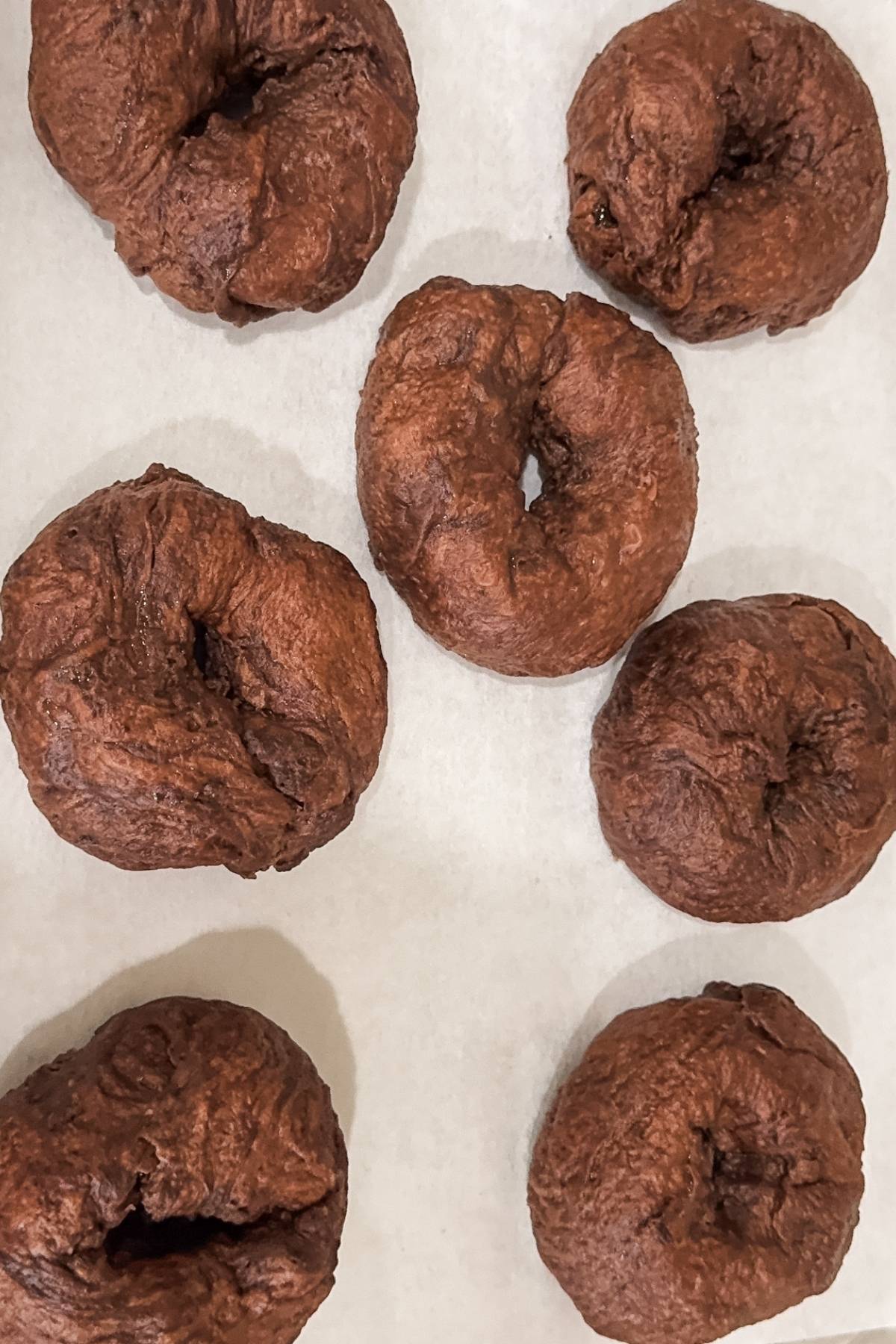 boiled bagels on a baking sheet