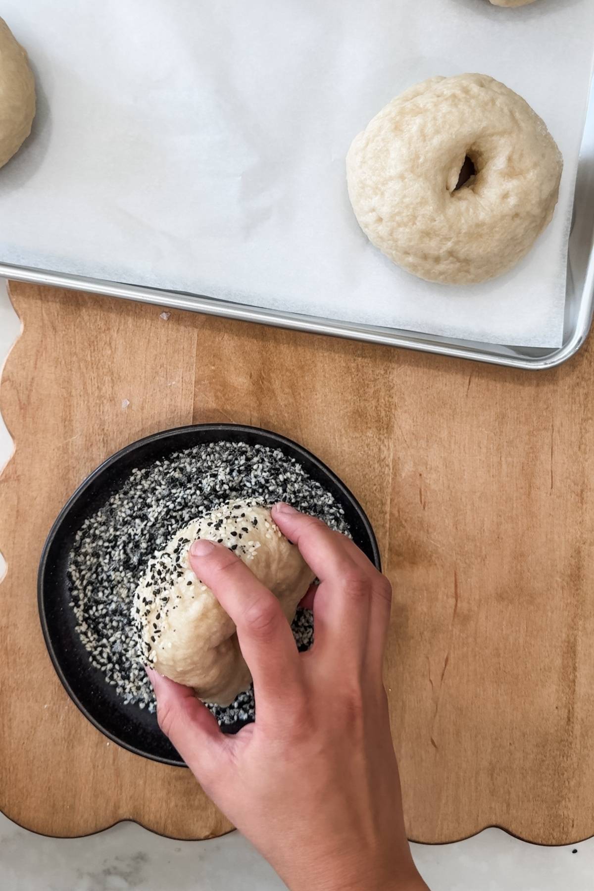 covering the top of a bagel with everything bagel seasoning
