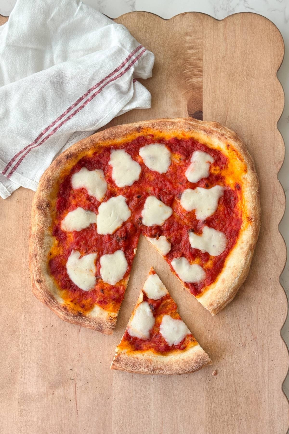 homemade pizza on a cutting board with a slice cut off