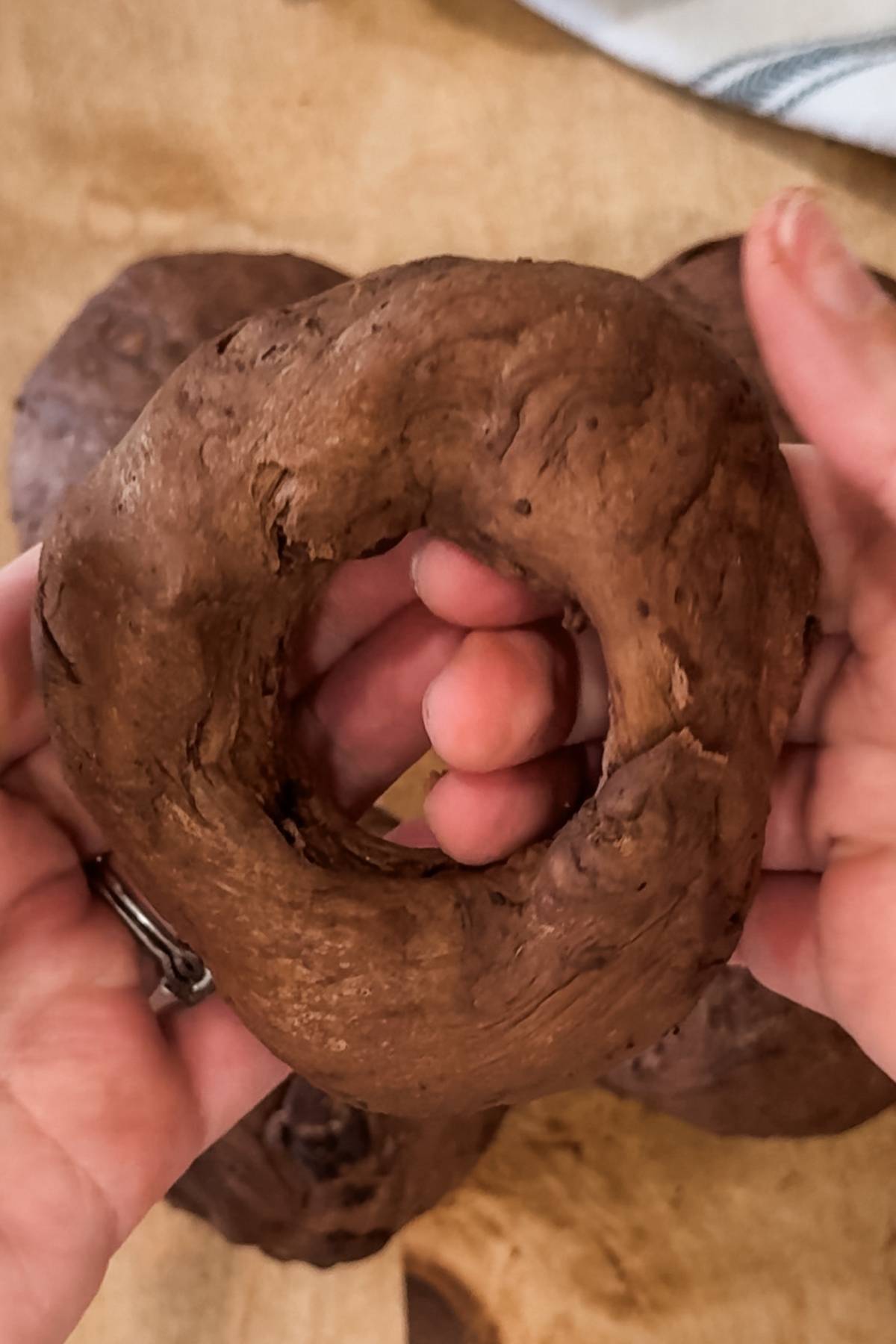 poking a hole in the chocolate bagel balls and turning them into rings