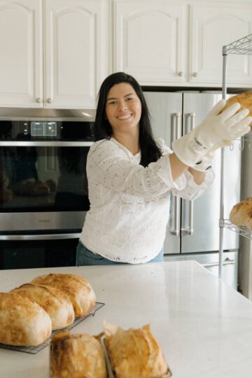 Maria putting bread on a cooling rack