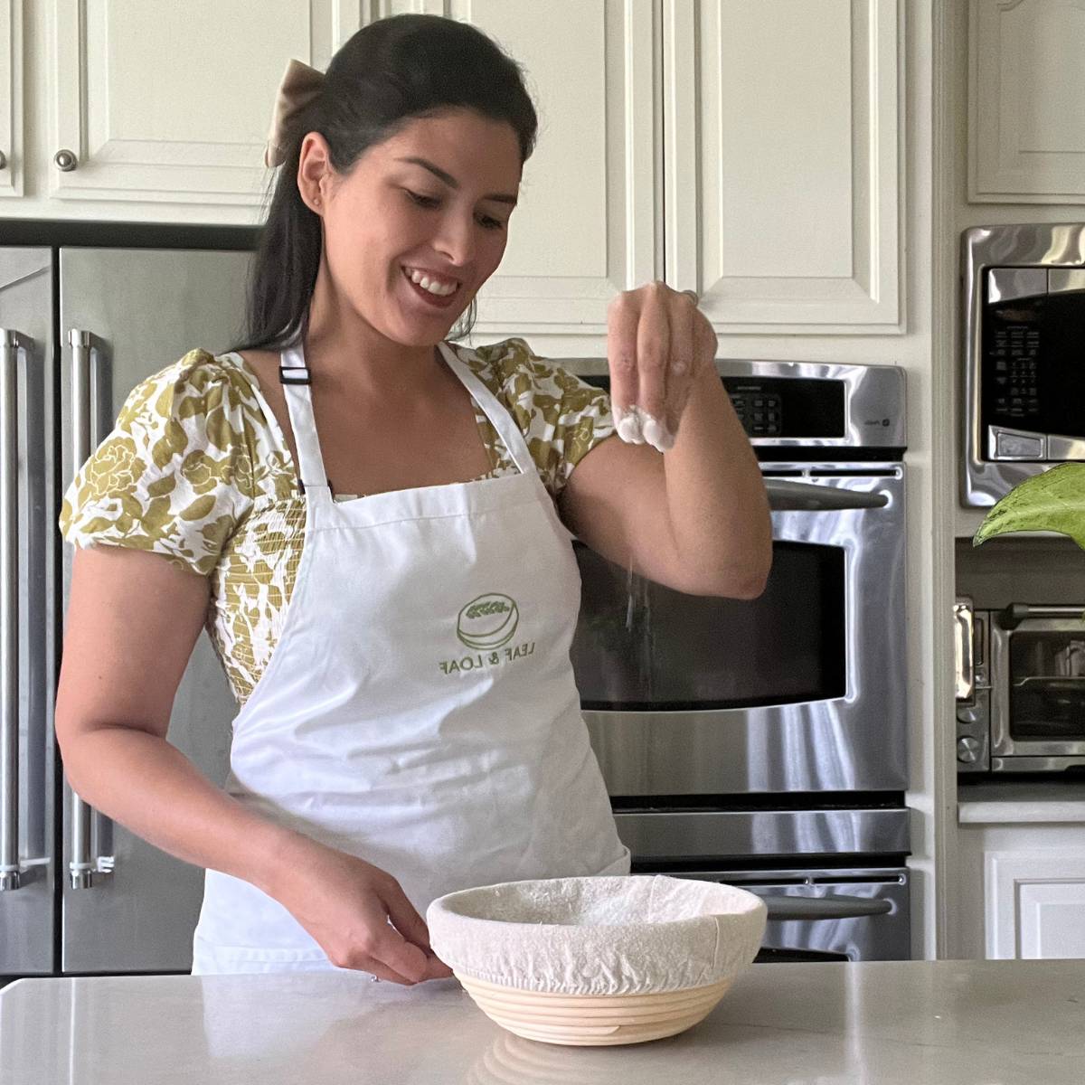 Maria Baradell dusting flour on a banneton