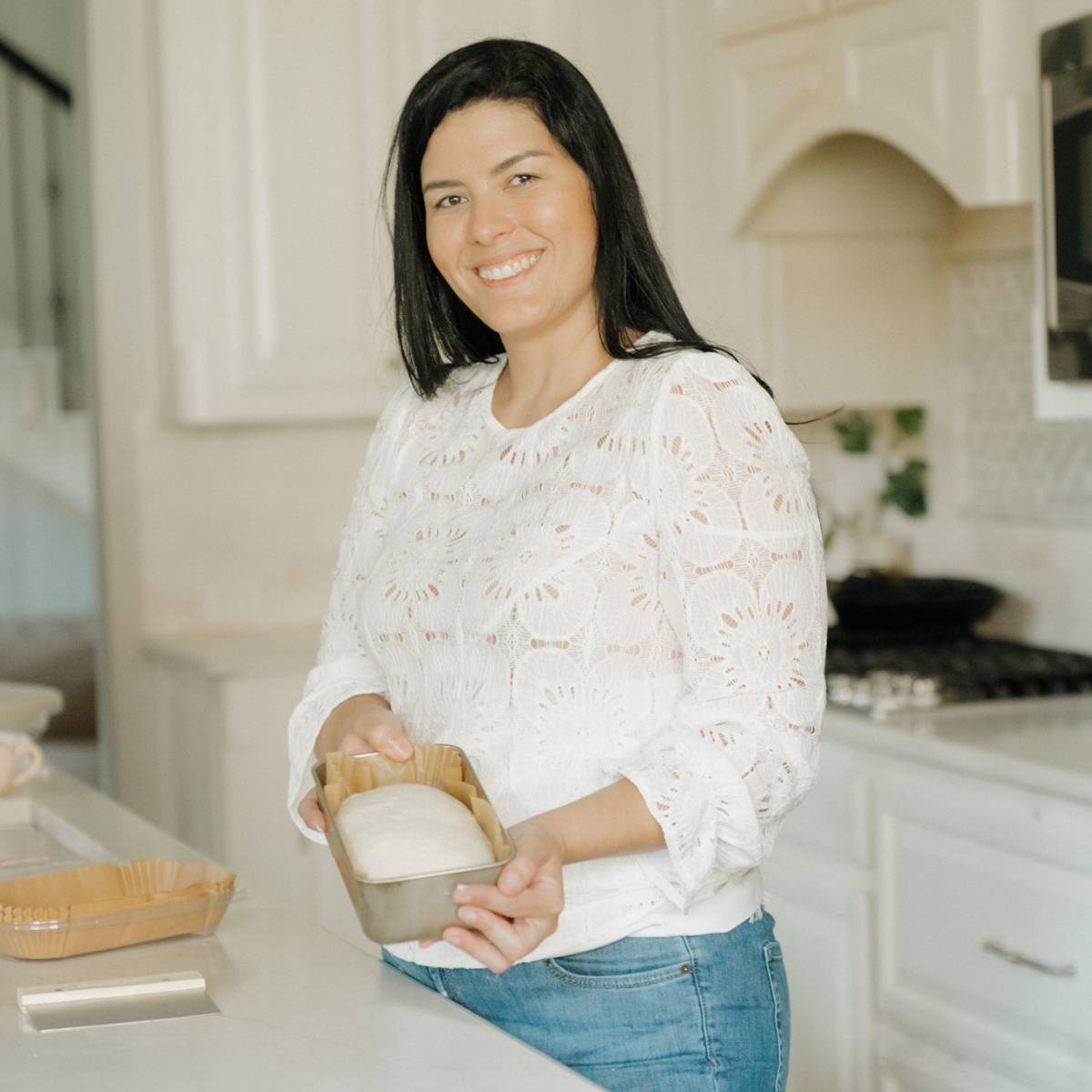 Maria Baradell showing a loaf pan with shaped dough ready for the second rise or proofing