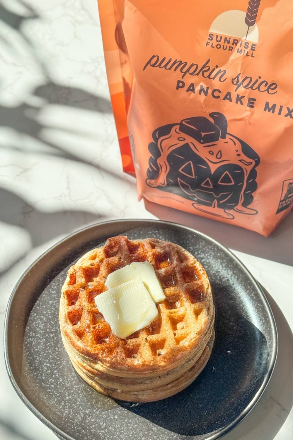 pumpkin spice waffles on a black plate