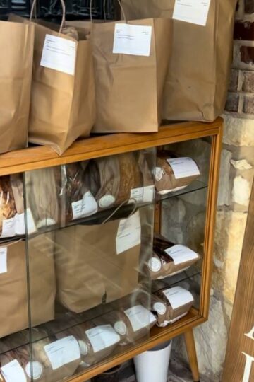brown bags filled with bread orders on an inside a stand outside Maria's home