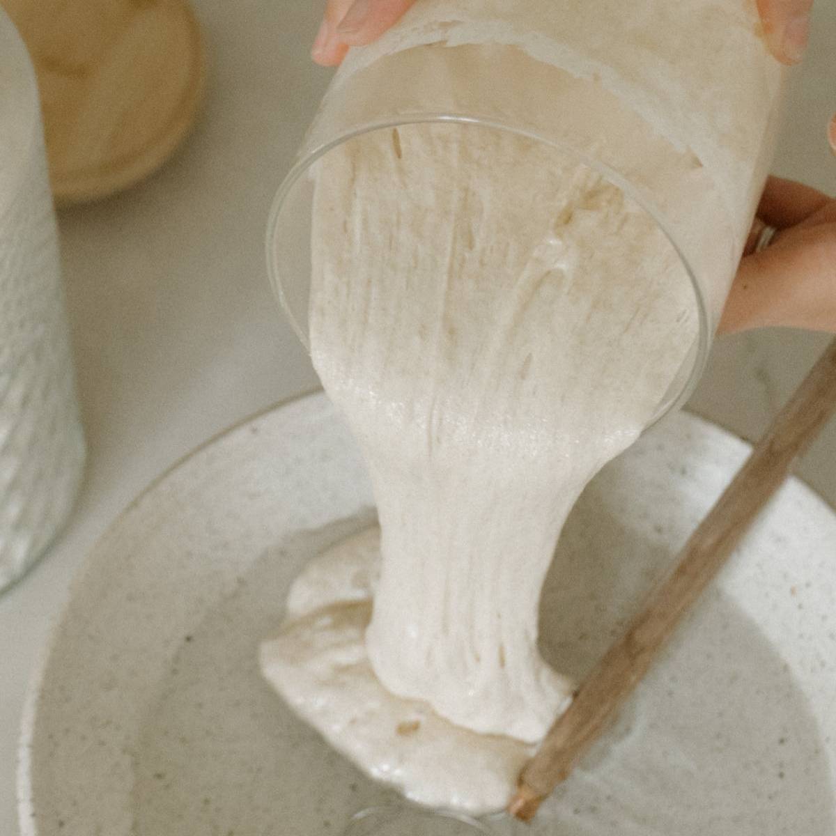 sourdough starter being poured on a bowl with water
