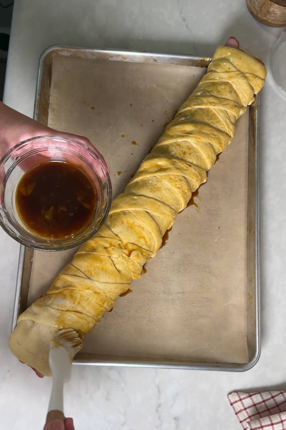 egg washing the Sourdough Pan de Jamon with egg and molasses before baking