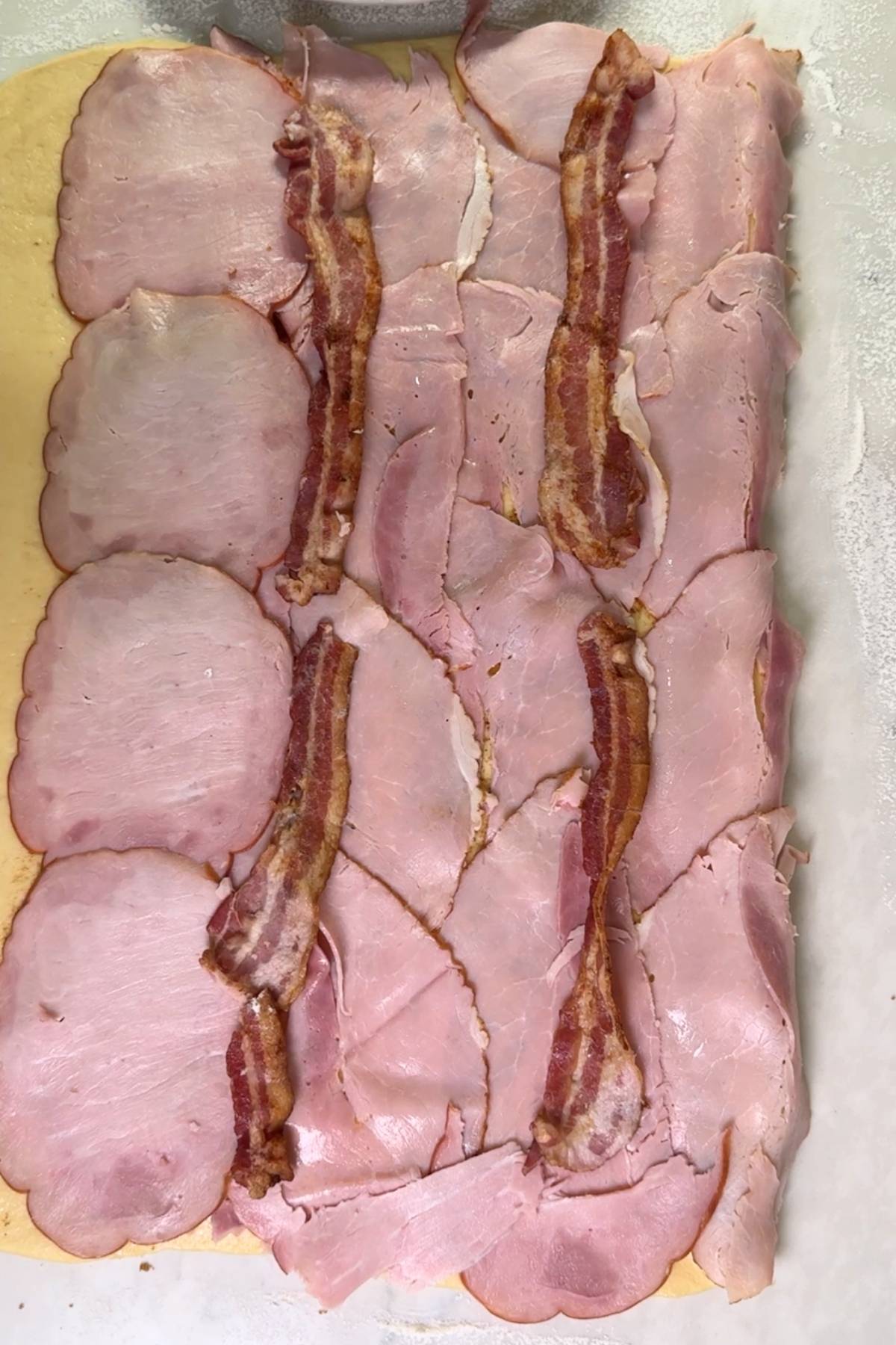 ham and bacon layared on the dough for Yeast Pan de Jamon